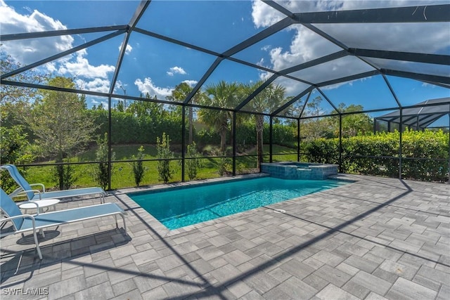 view of pool with a patio area, a pool with connected hot tub, and glass enclosure