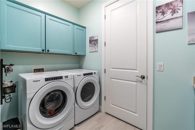 clothes washing area with cabinet space and washer and dryer