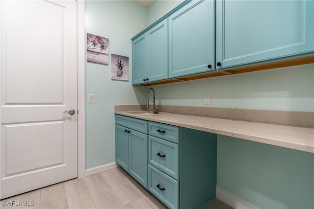 clothes washing area with a sink and baseboards