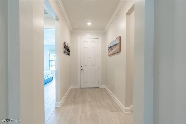 hallway with ornamental molding, recessed lighting, light wood finished floors, and baseboards