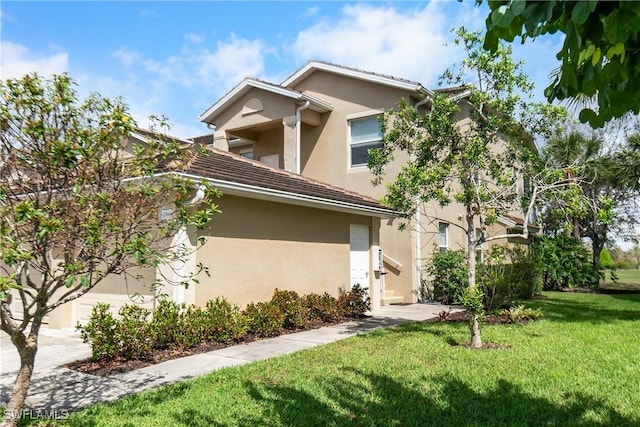 view of front of home with a front lawn and stucco siding