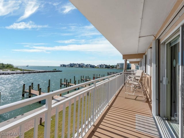 balcony featuring a boat dock, a water view, and a city view