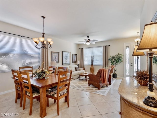 dining room with light tile patterned floors, baseboards, and ceiling fan with notable chandelier