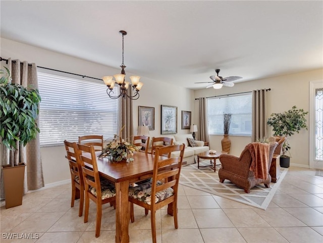 dining area with light tile patterned floors, ceiling fan with notable chandelier, and baseboards