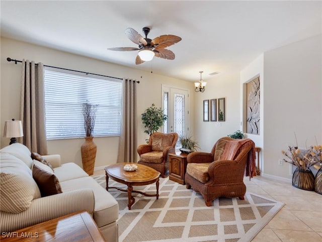 living room with light tile patterned floors, baseboards, visible vents, and ceiling fan with notable chandelier