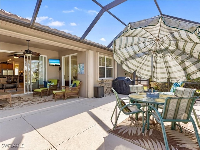 view of patio with ceiling fan, outdoor dining space, area for grilling, and a lanai