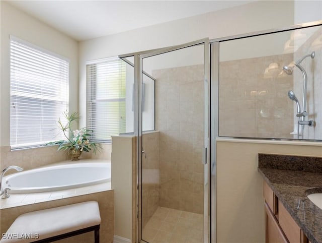 bathroom with a stall shower, a bath, and vanity