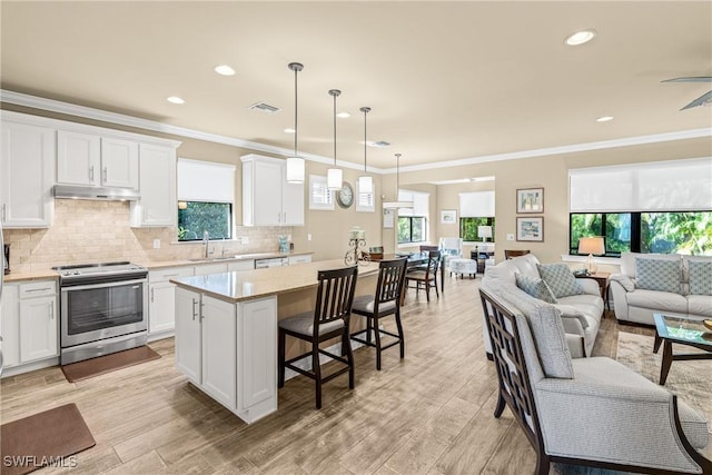 14671 Laguna Dr, Fort Myers, FL 33908 - kitchen featuring stainless steel electric range, under cabinet range hood, a sink, a center island, and open floor plan