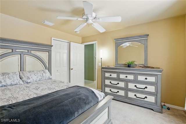 bedroom featuring ceiling fan, baseboards, a closet, and light carpet