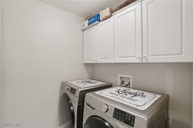 clothes washing area featuring cabinet space and separate washer and dryer