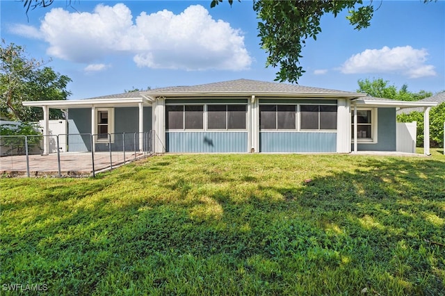 back of property with stucco siding, a lawn, fence, and a sunroom