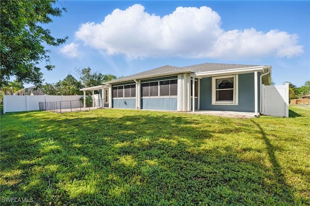 back of property featuring a yard, fence, a sunroom, and stucco siding