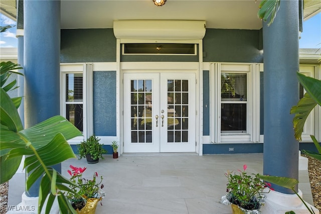 view of exterior entry with french doors and stucco siding