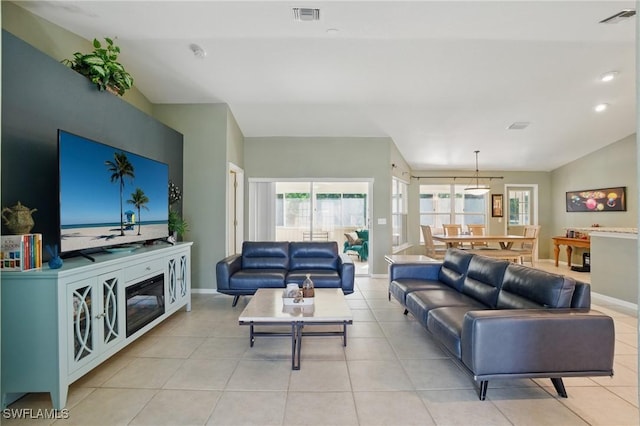 living room with a wealth of natural light, visible vents, and baseboards