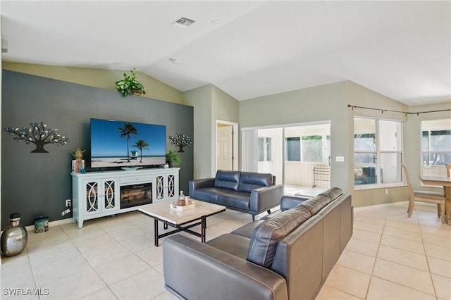 living area with visible vents, lofted ceiling, baseboards, and light tile patterned flooring