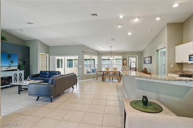 living room featuring light tile patterned floors, visible vents, and lofted ceiling