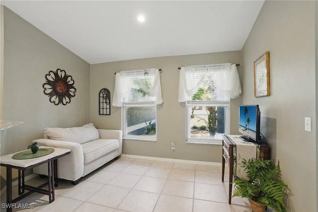 interior space with light tile patterned floors, baseboards, and lofted ceiling