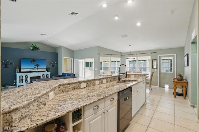 kitchen featuring a sink, light tile patterned floors, lofted ceiling, dishwasher, and light stone countertops