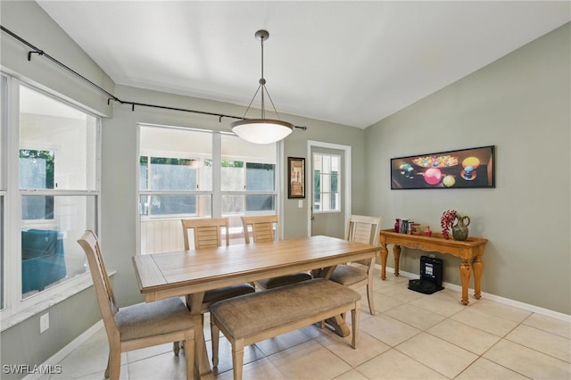 dining space with baseboards, light tile patterned flooring, and vaulted ceiling