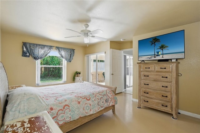 bedroom featuring ceiling fan, baseboards, and finished concrete floors