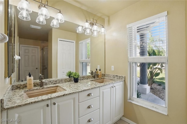 bathroom featuring double vanity, visible vents, baseboards, and a sink