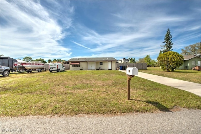 ranch-style home with driveway, a front yard, and fence