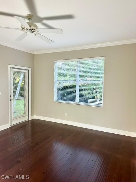 unfurnished room with dark wood-style floors, a healthy amount of sunlight, and baseboards