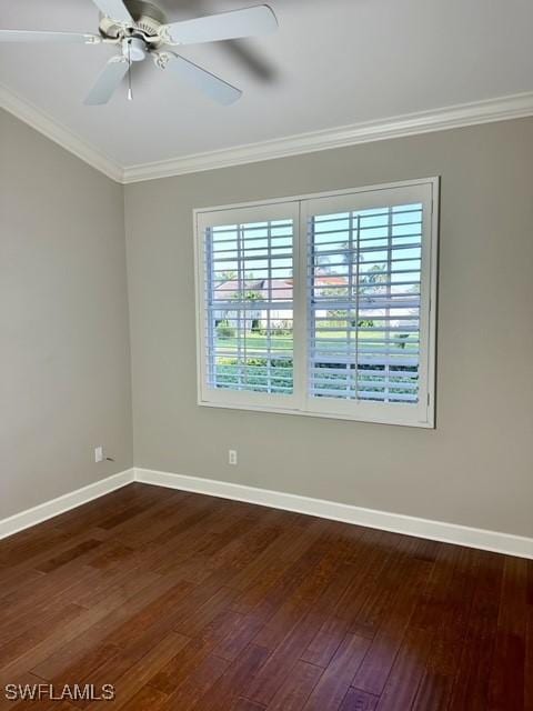 spare room featuring baseboards, ornamental molding, dark wood finished floors, and a ceiling fan