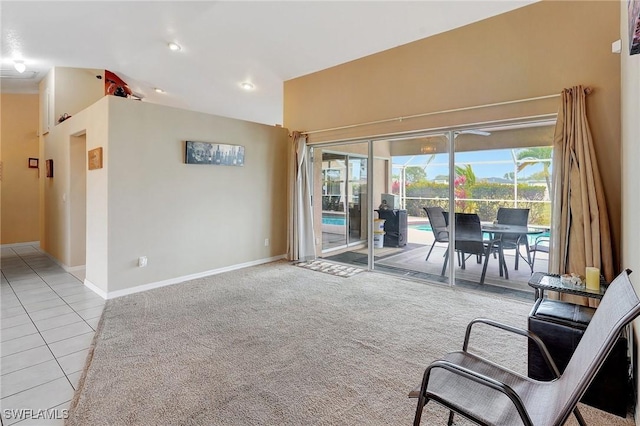 interior space with tile patterned flooring, lofted ceiling, plenty of natural light, and carpet flooring