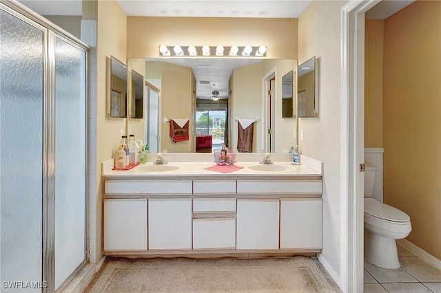 full bath featuring a sink, toilet, a shower stall, and tile patterned floors