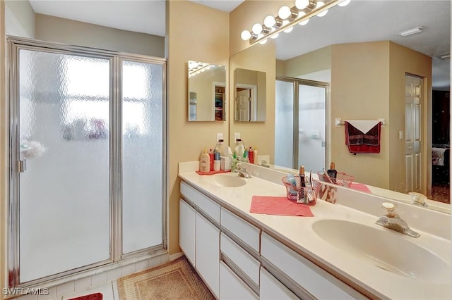 ensuite bathroom with a sink, ensuite bathroom, a shower stall, and tile patterned flooring