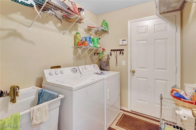 washroom featuring laundry area, washer and dryer, and a sink