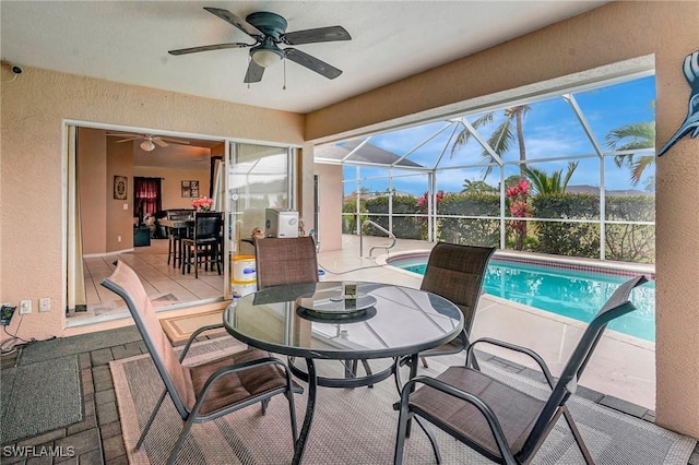 exterior space featuring outdoor dining space, a lanai, a ceiling fan, and an outdoor pool