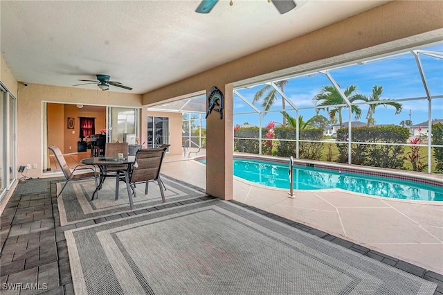 outdoor pool with a ceiling fan, a lanai, and a patio area