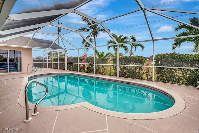 pool with glass enclosure and a patio area