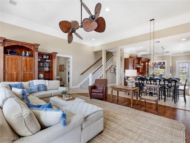 living area with wood finished floors, recessed lighting, stairway, crown molding, and baseboards