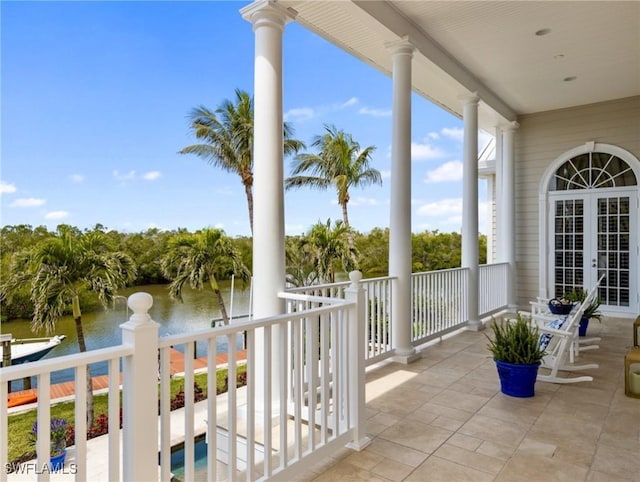 balcony featuring french doors and a water view