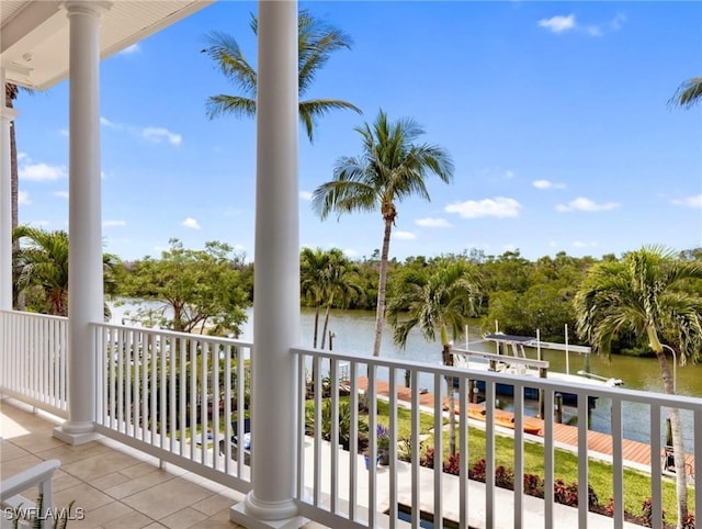 balcony with boat lift, a water view, and a boat dock