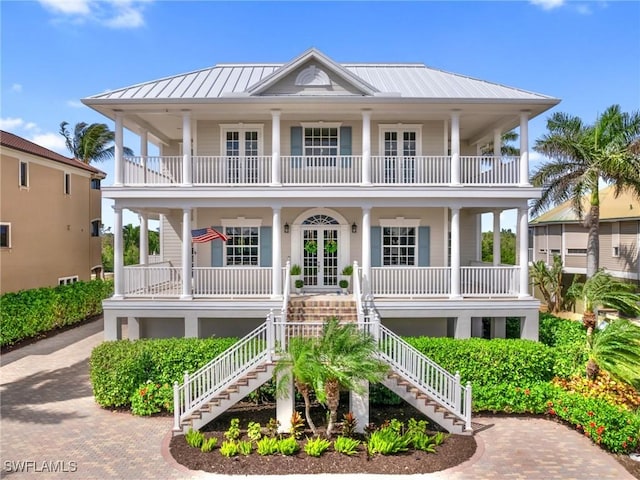 18200 Old Pelican Bay Dr, Fort Myers Beach, FL 33931 - raised beach house featuring a standing seam roof, stairway, french doors, metal roof, and a porch