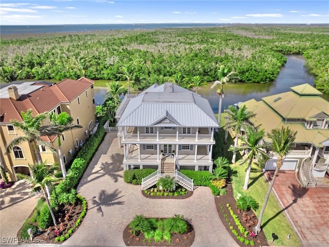 birds eye view of property featuring a forest view and a water view