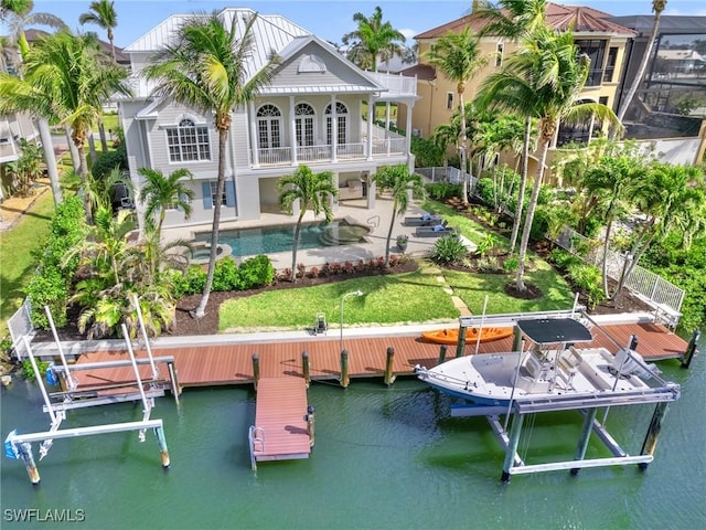 back of house featuring boat lift, an outdoor pool, a patio, and a water view