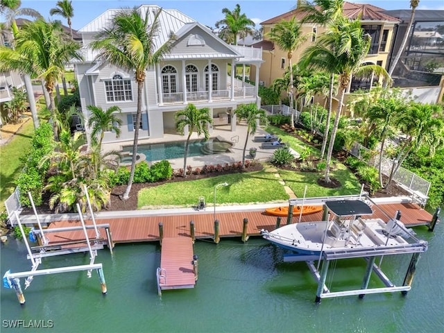 18200 Old Pelican Bay Dr, Fort Myers Beach, FL 33931 - rear view of house with a water view, boat lift, a patio area, and an outdoor pool