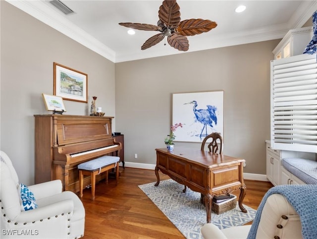 office featuring visible vents, baseboards, ceiling fan, ornamental molding, and light wood-style flooring