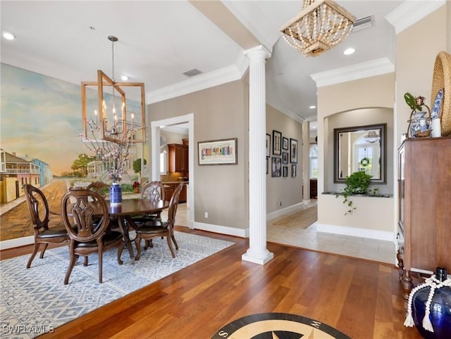 dining room featuring decorative columns, baseboards, a notable chandelier, and wood finished floors