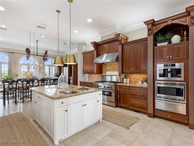 kitchen with a sink, appliances with stainless steel finishes, under cabinet range hood, a warming drawer, and a wealth of natural light