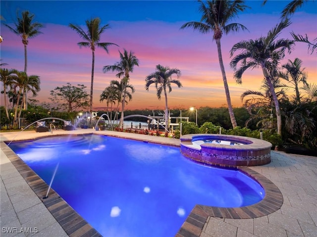 view of pool with a boat dock, a pool with connected hot tub, and a patio