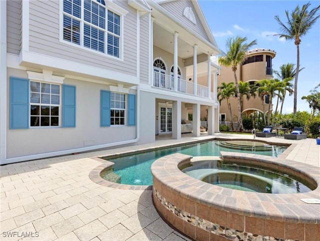 view of pool with a patio and a pool with connected hot tub