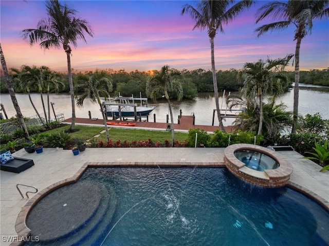 pool at dusk featuring a boat dock, a water view, a pool with connected hot tub, and boat lift