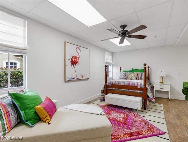 18200 Old Pelican Bay Dr, Fort Myers Beach, FL 33931 - bedroom featuring baseboards, wood finished floors, ceiling fan, and a drop ceiling