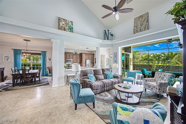 living area featuring light tile patterned floors, visible vents, high vaulted ceiling, and ceiling fan with notable chandelier